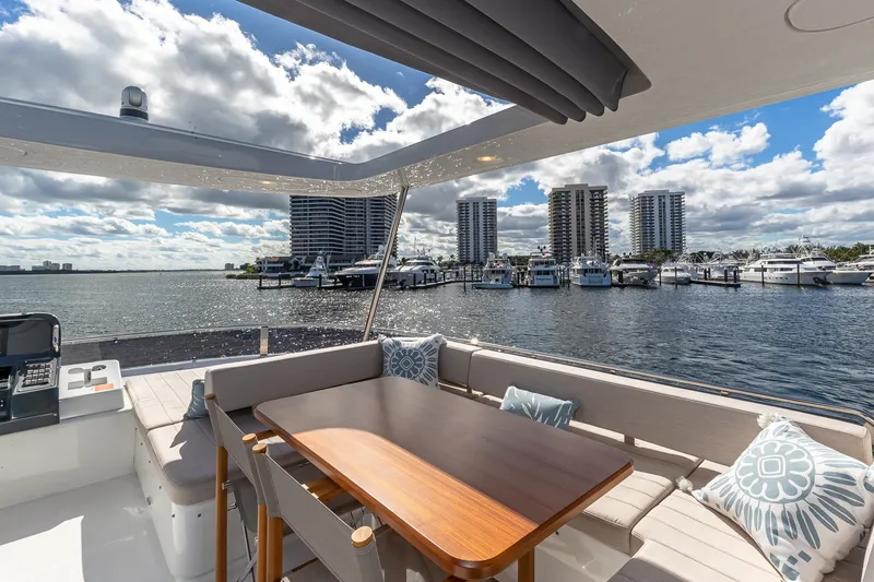 Slide: The Image of 2023 Sirena Flybridge yacht with elegant seating, docked at a marina under a partly cloudy sky. - 29