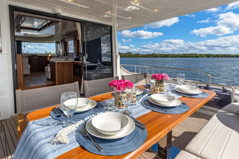 Slide: The Image of Luxurious 2023 Sirena Flybridge yacht dining area with elegant table setting and scenic water view. - 13