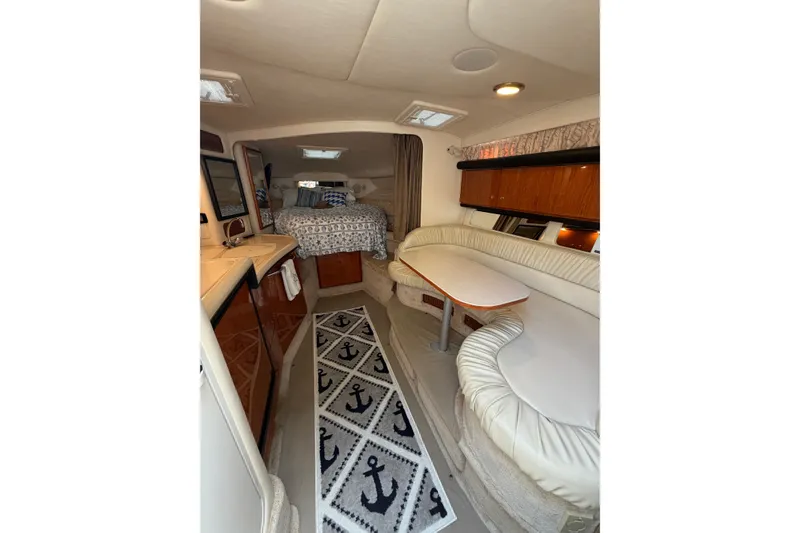 Slide: The Image of Interior of 2000 Sea Ray 340 Sundancer with cozy seating and nautical decor. - 16