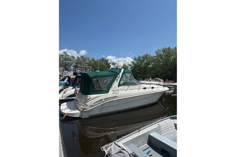 Slide: The Image of 2000 Sea Ray 340 Sundancer boat docked under clear blue sky. - 1