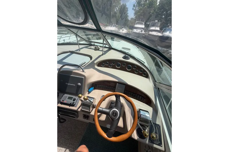 Slide: The Image of Cockpit view of 2000 Sea Ray 340 Sundancer with steering wheel and control panel. - 11