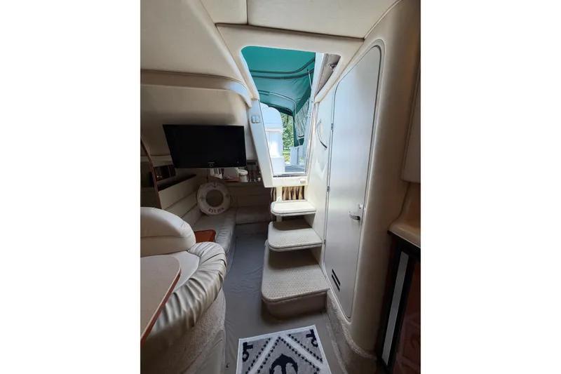 Slide: The Image of Interior of 2000 Sea Ray 340 Sundancer yacht with stairs, seating, and TV. - 21