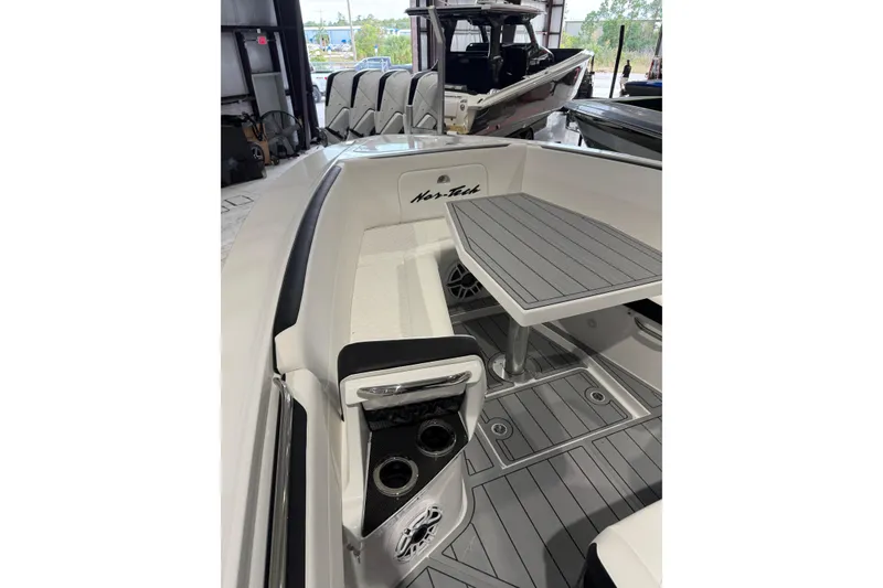 Slide: The Image of 2026 Nor-Tech 390 Sport Center Console interior with seating and table in a showroom. - 5