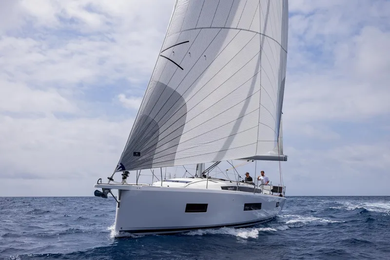 Slide: The Image of The 2026 Jeanneau Sun Odyssey 455 sails on open water with full sails. - 2