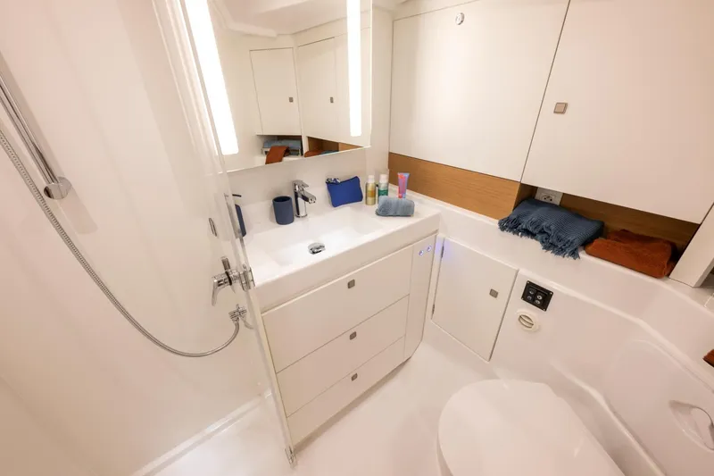 Slide: The Image of The image shows a modern yacht bathroom with white cabinets and a mirror. - 3