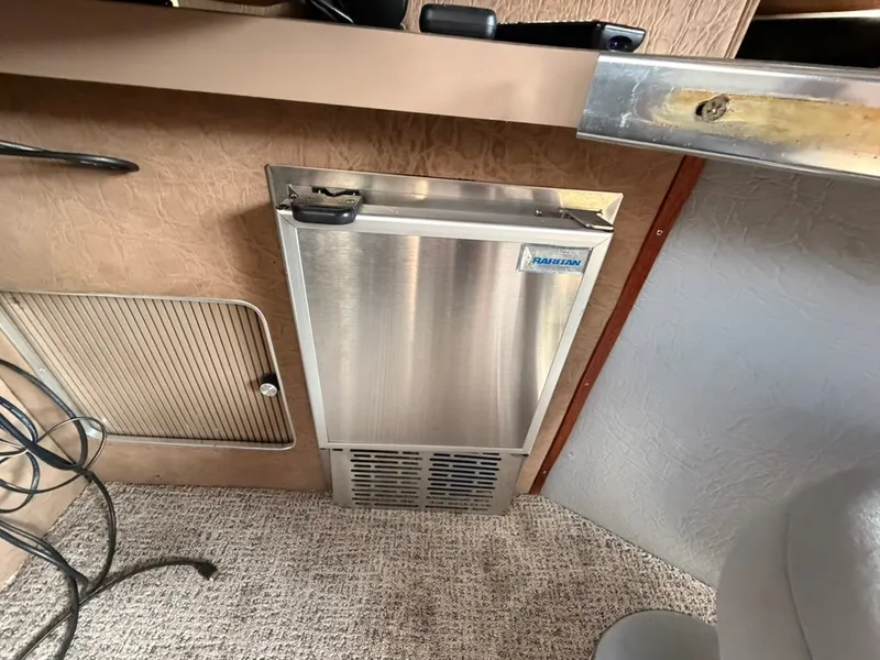 Slide: The Image of A small refrigerator is integrated into the boat's interior. Carpeted floor and wooden walls are visible. - 16