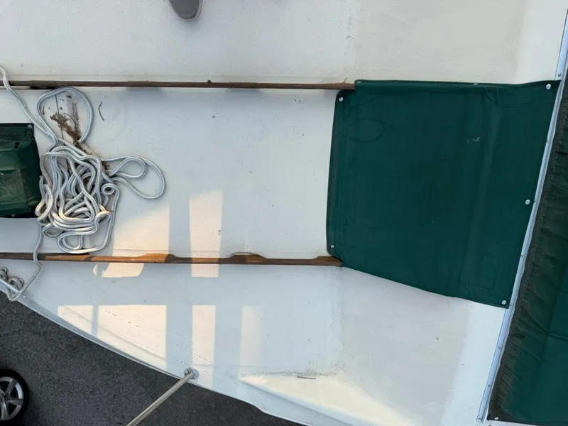 Slide: The Image of The image shows the deck of a 1981 Sea Ray 360 Sportfish with ropes and green covers. - 15