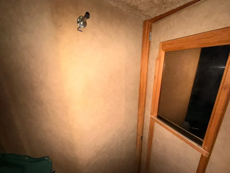 Slide: The Image of Interior of a 1981 Sea Ray 360 Sportfish with wooden doors and a window. - 32
