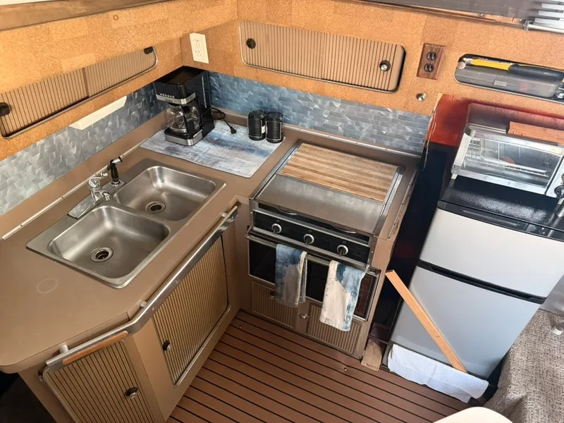 Slide: The Image of The galley of a 1981 Sea Ray 360 Sportfish with sink, stove, and refrigerator. - 19