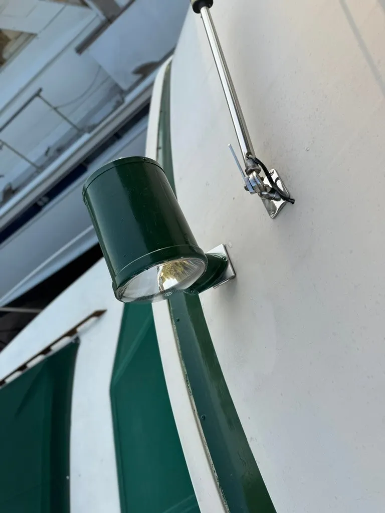 Slide: The Image of Close-up of a green boat light on a white boat. - 21