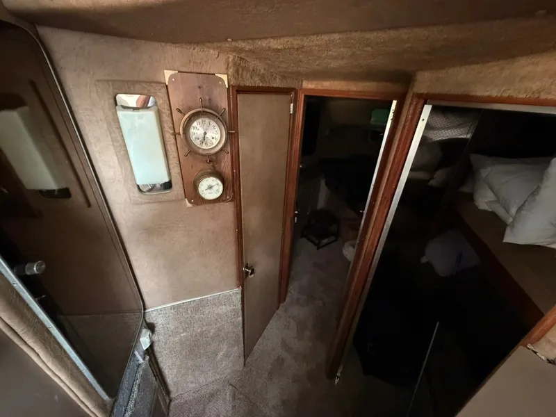 Slide: The Image of Interior of a 1981 Sea Ray 360 Sportfish with carpeted floor and wooden doors. - 20