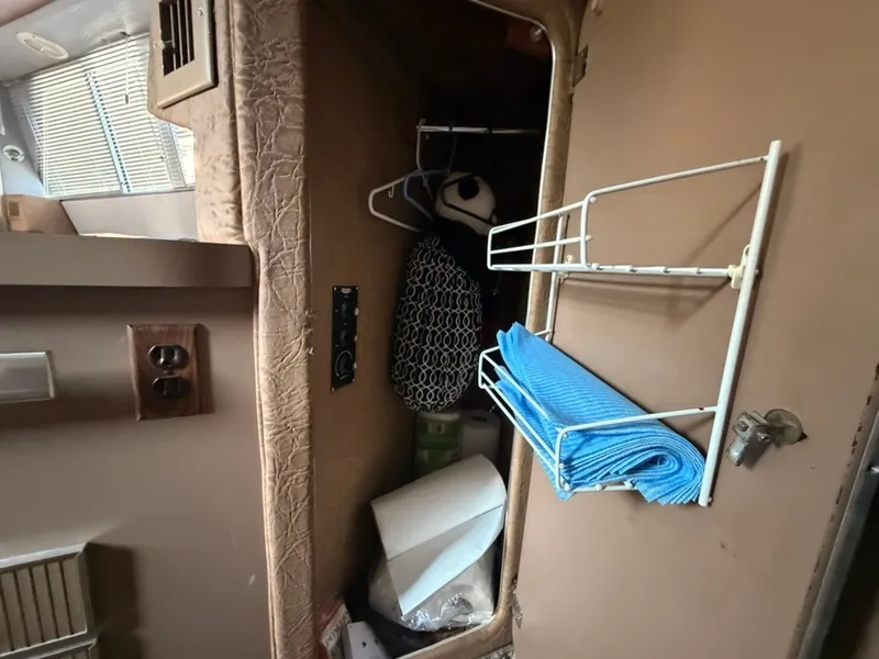 Slide: The Image of Interior of a 1981 Sea Ray 360 Sportfish with storage and blue towels. - 41
