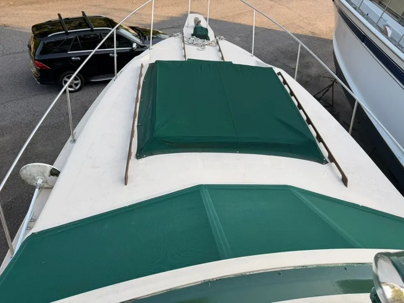 Slide: The Image of The image shows the foredeck of a 1981 Sea Ray 360 Sportfish with green covers. - 28
