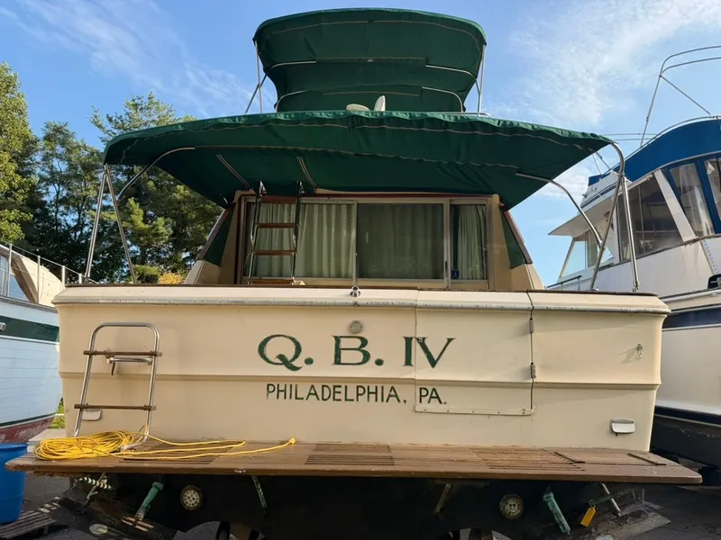 Slide: The Image of A 1981 Sea Ray 360 Sportfish with a green canopy, docked in Philadelphia. - 22