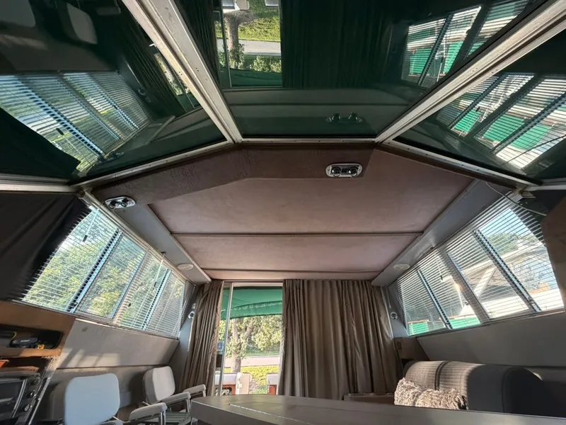 Slide: The Image of Interior of a 1981 Sea Ray 360 Sportfish with large windows and cozy seating. - 21