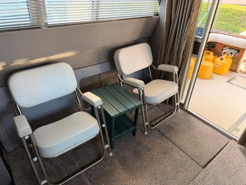 Slide: The Image of The interior of a 1981 Sea Ray 360 Sportfish features two white chairs and a small table. - 38