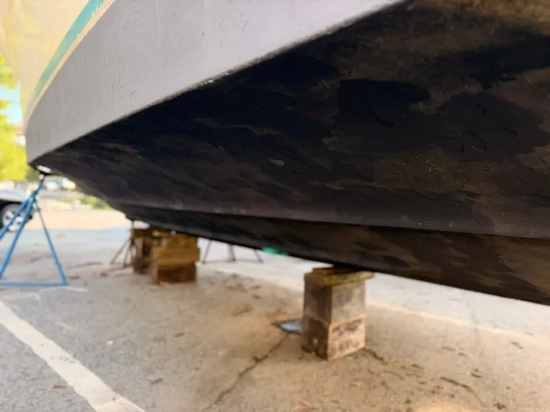Slide: The Image of Underside of a 1981 Sea Ray 360 Sportfish on supports on land. - 19