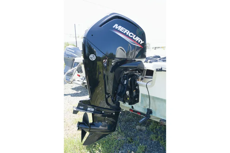 Slide: The Image of Mercury outboard motor on a 2006 Seapro 1996 Skiff, parked on gravel. - 13