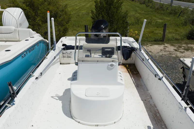 Slide: The Image of Seapro 1996 Skiff boat, 2006 model, with console and motor, parked outdoors. - 5
