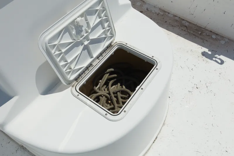 Slide: The Image of Open storage compartment on 2006 Seapro 1996 Skiff boat with coiled rope inside. - 10