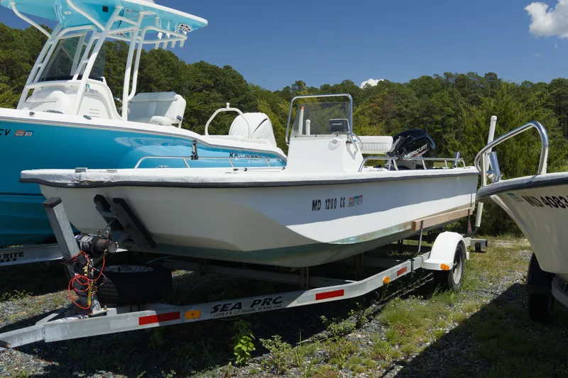 The Image of 2006 Seapro 1996 Skiff boat on trailer, parked outdoors with trees in background. - 0