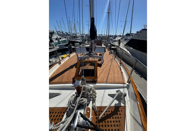 Slide: The Image of 1976 CT 48 sailboat with wooden deck, docked in a marina under clear blue skies. - 26