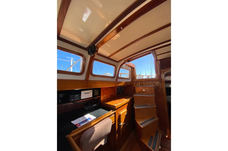 Slide: The Image of Interior of a 1976 CT 48 sailboat with wooden cabinetry and navigation equipment. - 22