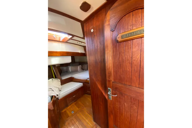 Slide: The Image of Wooden interior of a 1976 CT 48 yacht cabin with cozy bedding. - 15