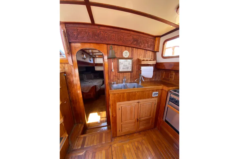 Slide: The Image of 1976 CT 48 yacht interior with wooden cabinetry, sink, and cozy cabin entrance. - 28