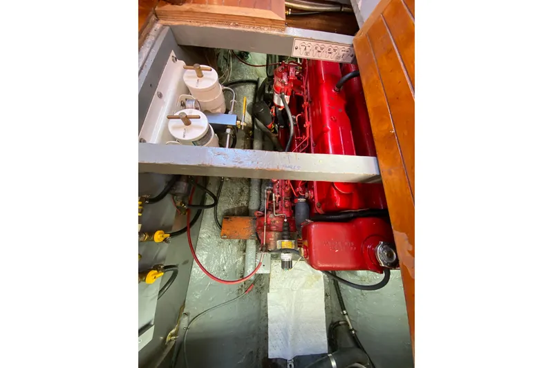 Slide: The Image of Engine compartment of a 1976 CT 48 boat, featuring a red engine and filters. - 20