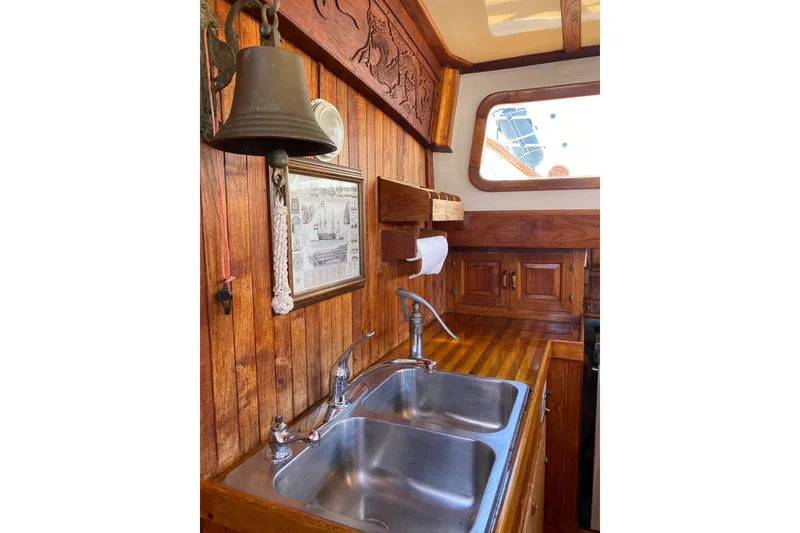 Slide: The Image of Vintage 1976 CT 48 yacht kitchen with wooden cabinetry, dual sinks, and nautical decor. - 18