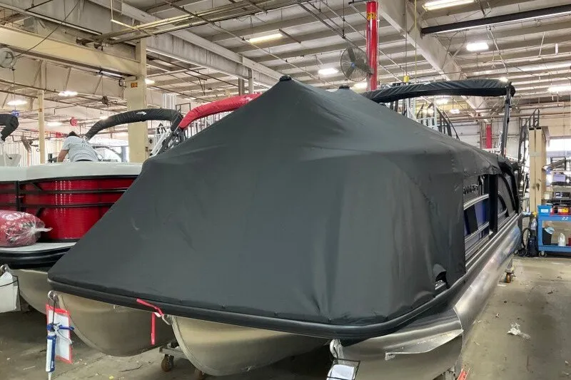 Slide: The Image of 2027 Bennington 23 M Swingback pontoon boat covered in a protective tarp in a warehouse. - 16