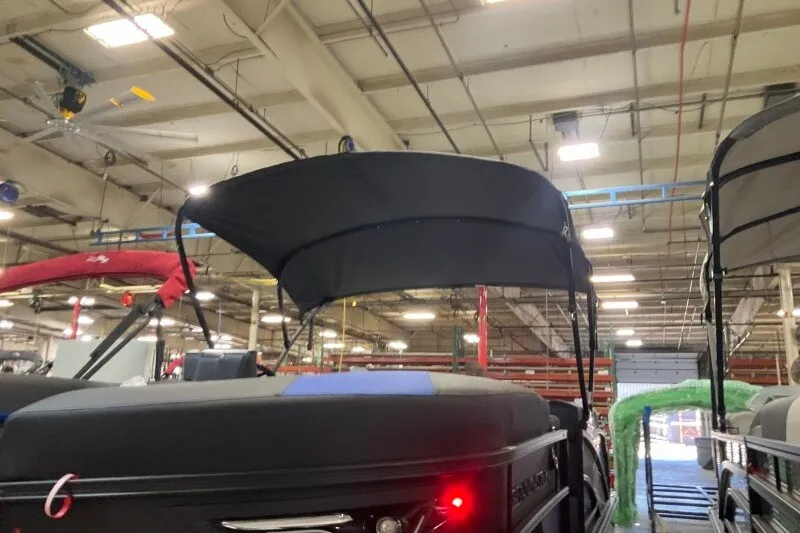 Slide: The Image of 2027 Bennington 23 M Swingback boat with canopy in a warehouse setting. - 15