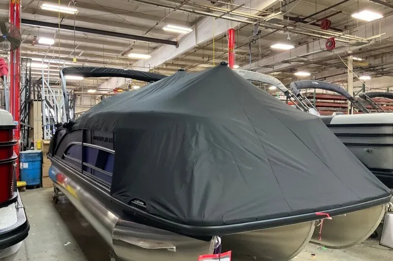 Slide: The Image of 2027 Bennington 23 M Swingback pontoon boat covered in a factory setting. - 17