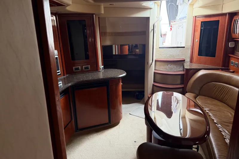 Slide: The Image of Interior of 2005 Sea Ray 420 Sundancer yacht with elegant wood finishes and seating area. - 12