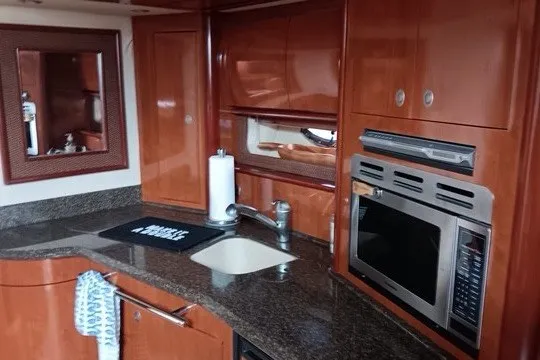 Slide: The Image of Luxurious 2005 Sea Ray 420 Sundancer yacht kitchen with modern appliances and elegant wood cabinetry. - 11