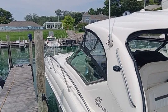 Slide: The Image of 2005 Sea Ray 420 Sundancer yacht docked at a marina with scenic waterfront views. - 1