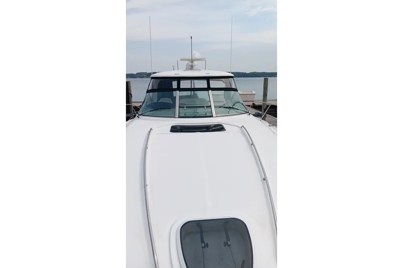Slide: The Image of 2005 Sea Ray 420 Sundancer yacht docked, showcasing sleek design and spacious deck. - 6