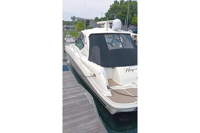 Slide: The Image of 2005 Sea Ray 420 Sundancer docked at marina, featuring sleek design and covered cockpit. - 5