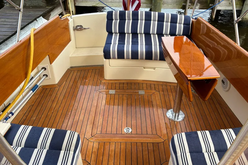 Slide: The Image of 2014 Hinckley Picnic Boat 37 MKIII interior with striped seating and polished wood flooring. - 14