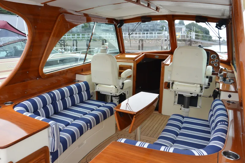 Slide: The Image of Interior of 2014 Hinckley Picnic Boat 37 MKIII with striped seating and wooden finishes. - 17