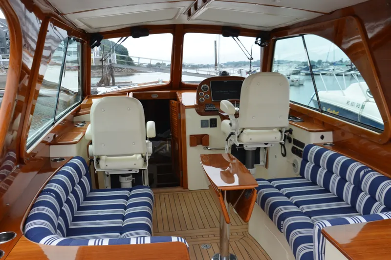 Slide: The Image of Interior of 2014 Hinckley Picnic Boat 37 MKIII with striped seating and wooden finishes. - 16