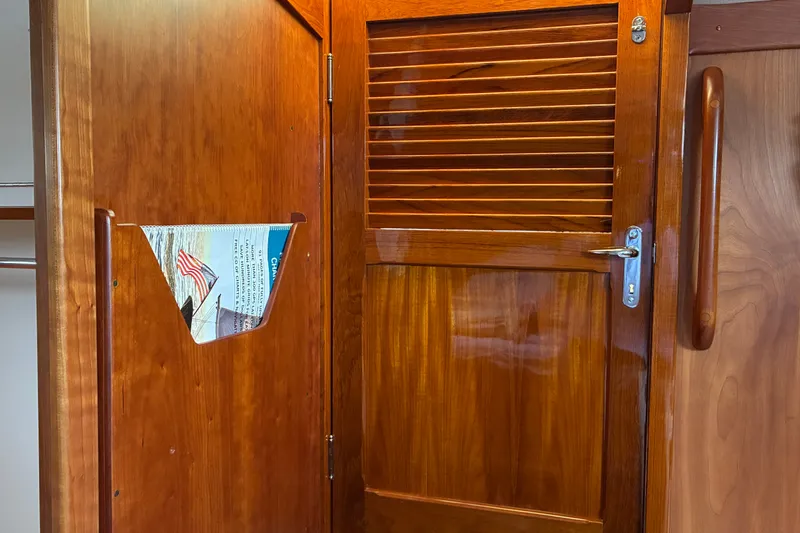 Slide: The Image of Wooden interior of 2014 Hinckley Picnic Boat 37 MKIII, featuring a louvered door and magazine holder. - 28