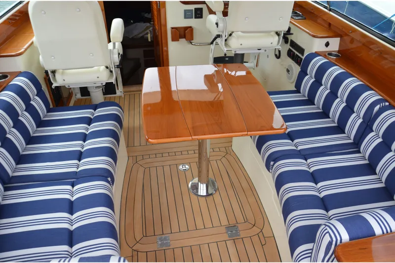 Slide: The Image of Luxurious interior of 2014 Hinckley Picnic Boat 37 MKIII with striped seating and wooden table. - 18