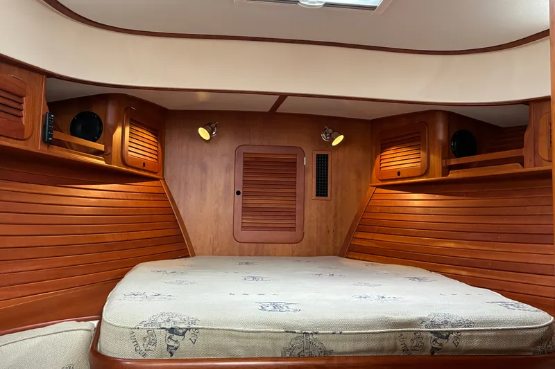 Slide: The Image of Interior of 2014 Hinckley Picnic Boat 37 MKIII with wooden paneling and cozy sleeping area. - 40