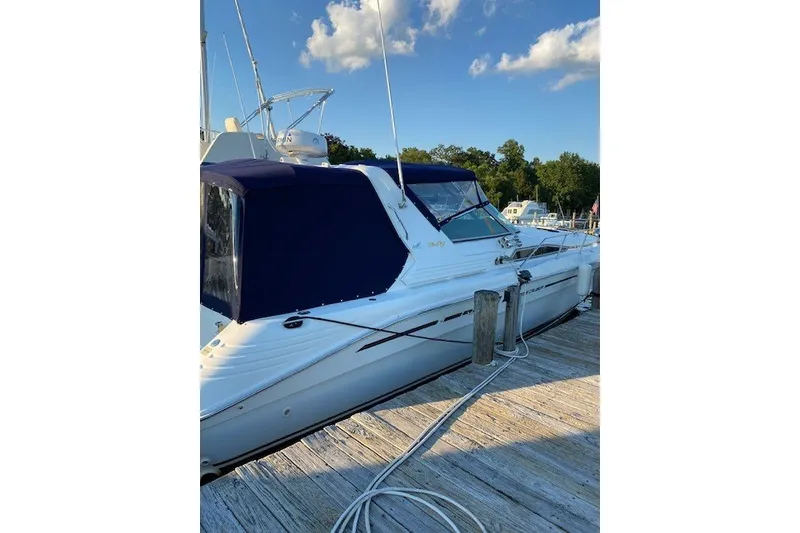 Slide: The Image of 1992 Sea Ray 400 Express Cruiser docked, featuring sleek design and blue canopy. - 2