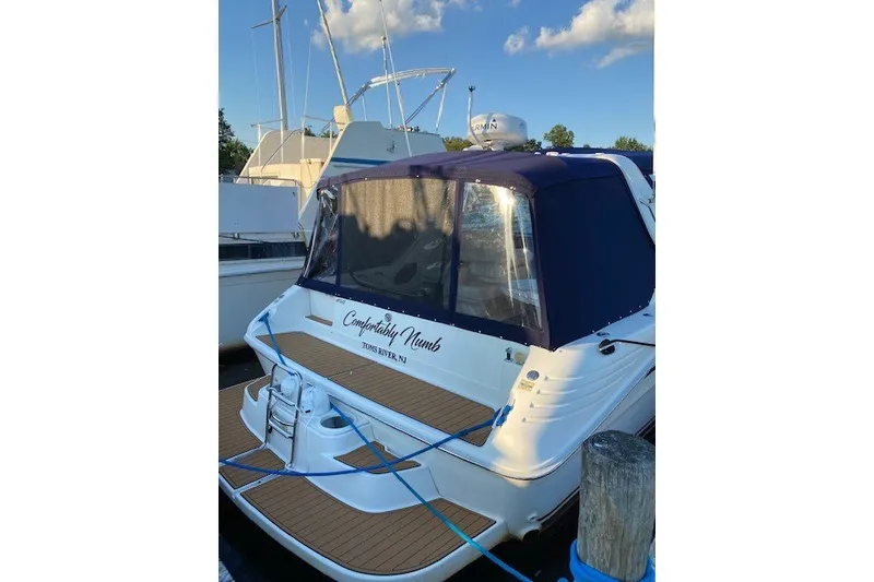 Slide: The Image of 1992 Sea Ray 400 Express Cruiser docked, featuring blue canopy and wooden deck. - 1