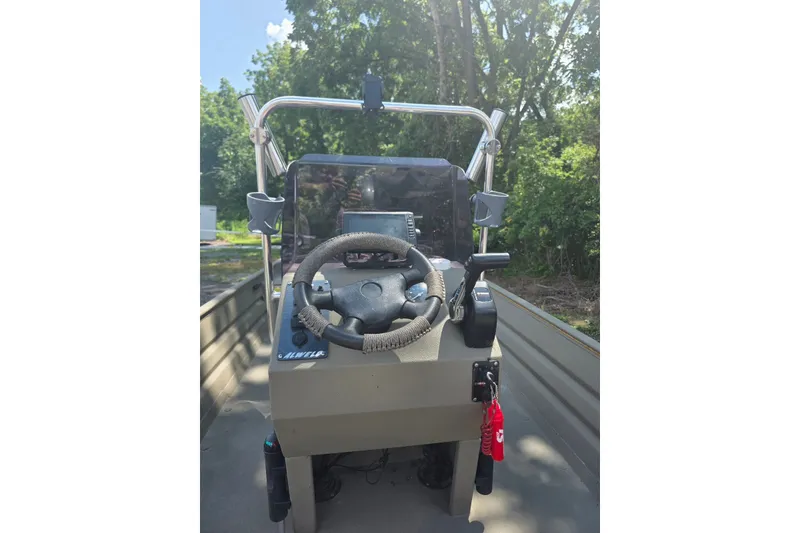 Slide: The Image of 2017 Alweld 1756VCC Angler boat console with steering wheel and controls, outdoors. - 3