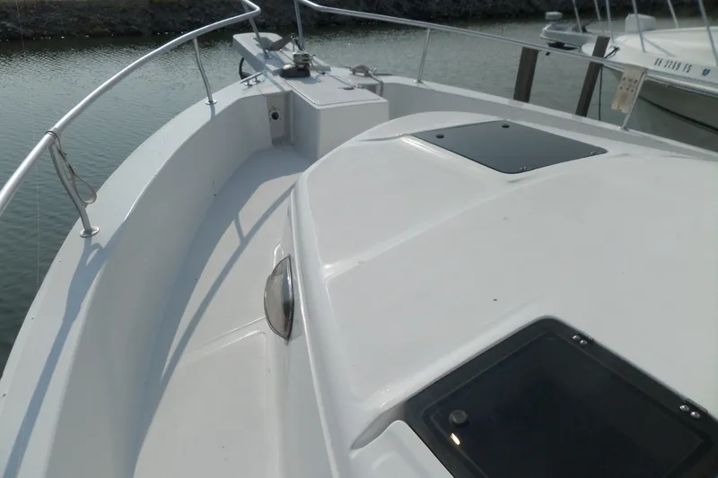 Slide: The Image of 1997 Mainship 350 Trawler deck view, featuring sleek design and railing details. - 60