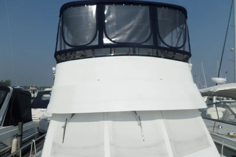 Slide: The Image of 1997 Mainship 350 Trawler docked, featuring a white hull and enclosed upper deck. - 55